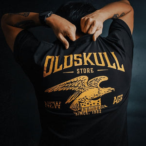 This shirt is similar to the Harley Davidson style of shirts.  It is black with orange print.  It has a small Oldskull Shirts logo on the front.  On the back it has an large eagle over a shield design with the words Oldskull Store written over it.  It is a vintage streetwear design. 